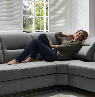 Frau entspannt auf grauem Sofa