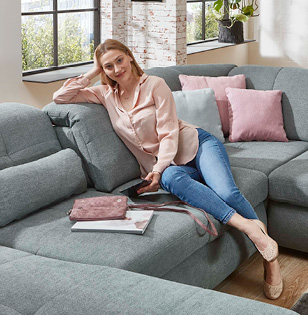 blonde Frau liest auf blauer couch
